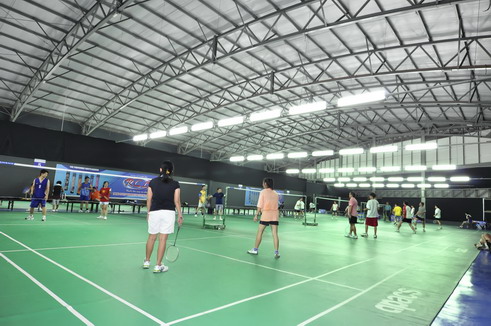 Badminton players competing under indoor lights